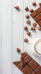 A glass of chocolate milk sits on a white wooden table next to a stack of dark chocolate squares and fresh mint leaves