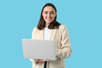 Young businesswoman with laptop on blue background