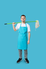 Male janitor with floor mop on blue background