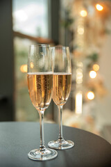 Two glasses of champagne fizzing on the table close-up