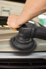 Car detailing enhances shine of vehicle with machine buffer for glossy finish