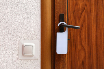Wooden door with white hanger in hotel room