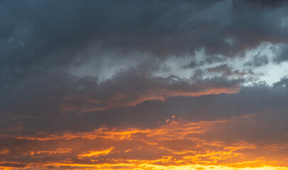 Sky background. Bright orange sunset sky with clouds.