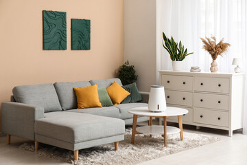 Modern humidifier on coffee table near chest of drawers in stylish living room