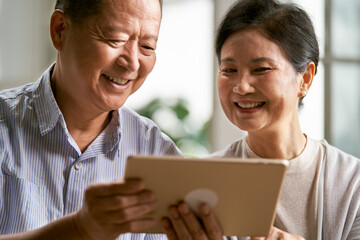 senior asian couple using digital tablet together at home