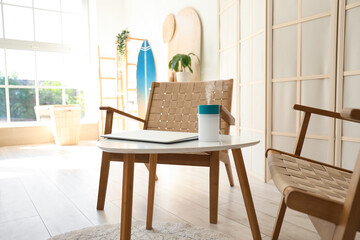 Air humidifier with laptop on table near armchair in living room