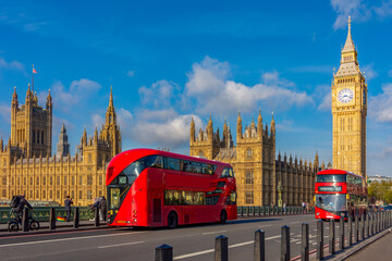 Houses of Parliament with Big Ben and double-decker buses on Westminster bridge, London, UK