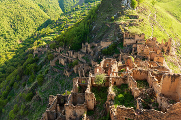 View from above on the remains of stone buildings in an abandoned ancient village of Ghusa Gamsutl in Dagestan