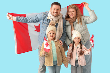 Happy beautiful family with flags of Canada on blue background