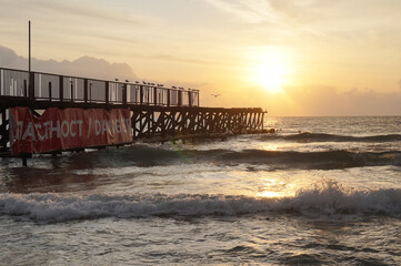 Sunrise on the sea, waves and sand, summer background.