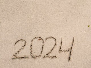 Hand made sign 2024 on a sand beach