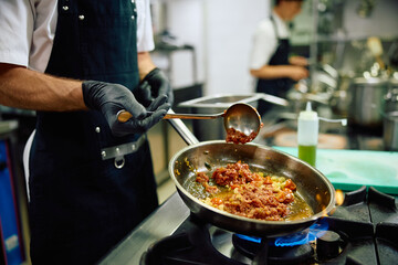 Close up of professional cook working in a restaurant.