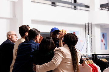 Security officer handling crowd and reducing violence while patrolling fashion store entrance....