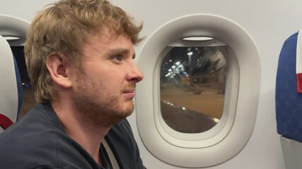 young man afraid to fly on an airplane, fear of heights, aerophobia