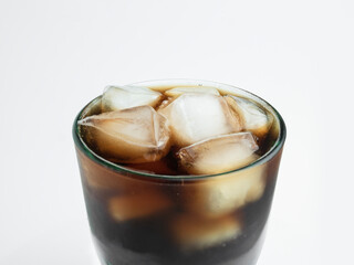 glass full of soda drink and ice cubes. close up shallow depth of field