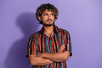 Photo of serious man with beard wavy hairdo dressed print shirt hold arms folded look empty space isolated on purple color background