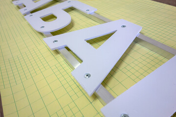 Plastic three-dimensional letters on the frame.Production of outdoor advertising.Light letters.
