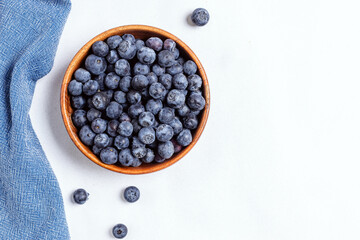 Fresh blueberries in a wooden bowl, top view