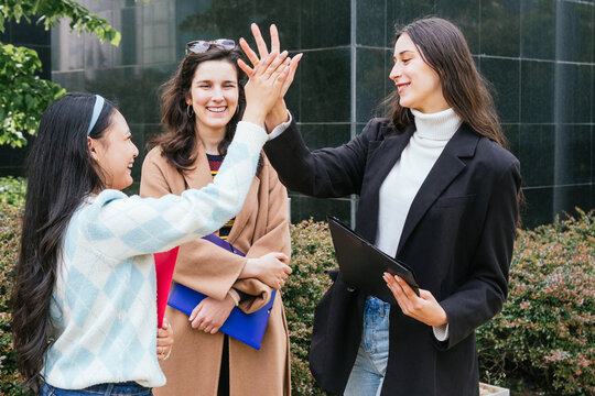 Celebrating academic success with high fives outdoors