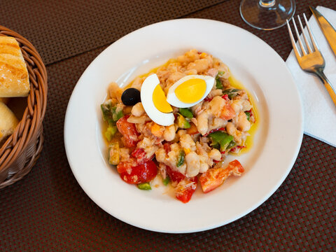 Appetizing bean salad empedrat with tuna egg and tomato served on platter