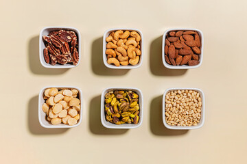 Various types of dry nuts in a small bowls, overhead view. Healthy fat, essential nutrient