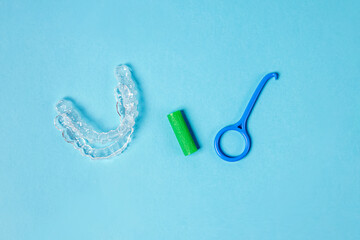 Two invisible removable aligners and accessory tools on the blue background.