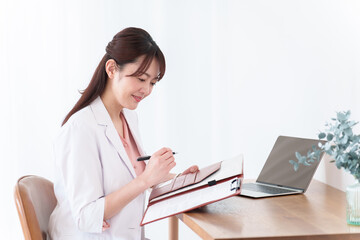 カルテに記入する医師