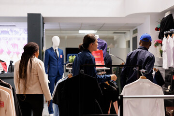 Peak season in retail. Fashion boutique employees and security guard working in clothing store...