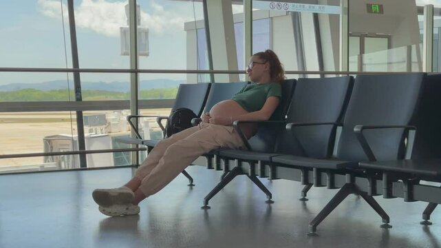 happy pregnant woman traveling alone, waiting for plane at airport, second or third trimester 