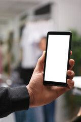 Shopping center boutique customer using smartphone blank digital display and checking sale on online website. Man hand holding mobile phone with empty screen in store closeup