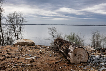 A muddy field with a puddle in the center surrounded by grass