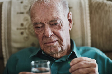 Elderly man, water and pills for healthcare with retirement, prescription and supplements in home. Senior person, glass and pharmaceutical drugs for chronic arthritis, pain medication and wellness