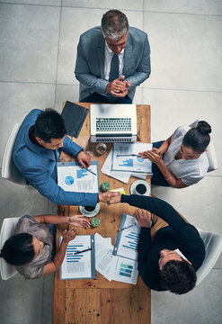 Above, business and people with handshake in office for finance report, investment deal and negotiation success. Men, women and agreement of financial proposal, documents and b2b opportunity together