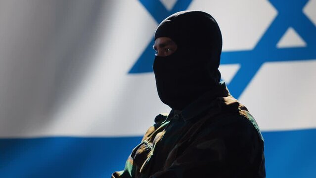 Mossad intelligence corps agent standing proud in front of Israel flag, feeling pride in serving country. Close up shot of Israeli counterintelligence operation spy in war room crossing arms, camera A