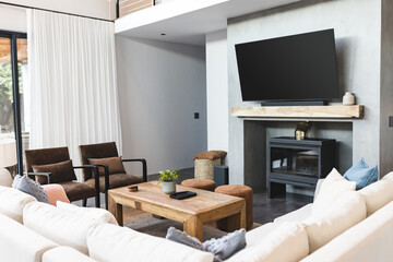Modern living room with large TV, cozy seating, and wooden coffee table, copy space