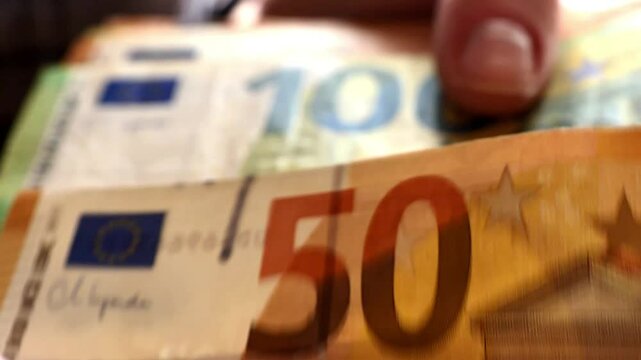 Counting money. stack of euro bills in womens palms. Fingers fingering euro bills close-up. Spending and income in Europe. 