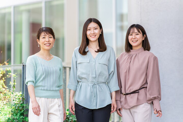 ビルの前に立つ3人のビジネスウーマン・女友達・大学生（アジア人,日本人,中国人・女性）
