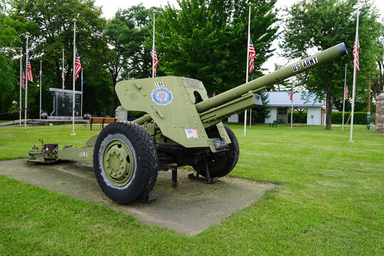 WW 2 United States Army Ordnance QF 25-pounder howitzer cannon sits on display at a veteran's memorial site.