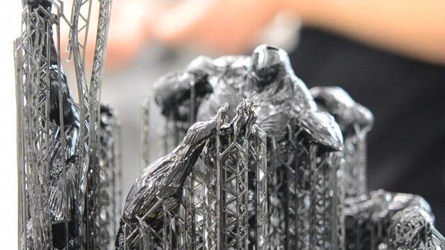 Black model with supports printed on 3D printer close-up. Part of object created on 3D printer from hardened rubber under influence of ultraviolet light. SLA 3D printing technology. Stereolithography