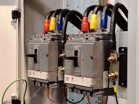 Close up image of three phase cable connection breaker in low voltage electrical board.