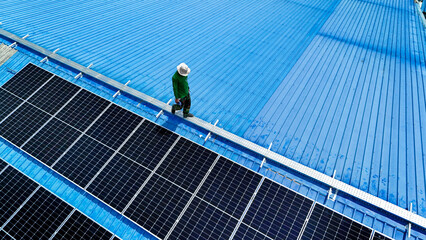 Worker Technicians are working to construct solar panels system on roof. Installing solar photovoltaic panel system. Men technicians walking on roof structure to check photovoltaic solar modules.