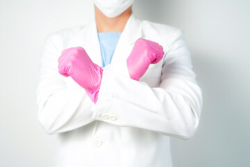 Stop gesture, arms crossed in pink gloves, sign protest, rejection, on white background