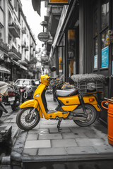 A yellow scooter is parked on the sidewalk in front of a building