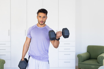 Lifting dumbbells, man exercising at home for fitness and strength training