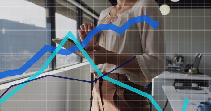 Image of statistical data processing over mid section of woman using digital tablet at office