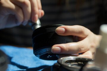 Photograph of hands cleaning a camera lens. Concept of photography.