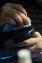 Photograph of hands cleaning a camera lens. Concept of photography.