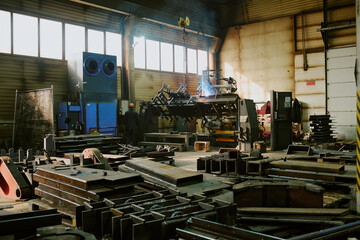 Wide shot of heavy machinery production factory interior with huge metal parts in workshop, copy space