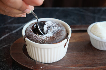 Delicious Chocolate Lava Cake with Powdered Sugar and Whipped Cream on Wooden Plate