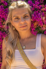 Captivating Portrait of a Beautiful Blonde Woman with Long Hair and Brown Eyes, Elegantly Captured in a Vibrant Floral Setting